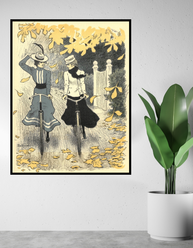 Denne vintageplakat forestiller to kvinder som cykler en cykeltur i efteråret, hvor gule blade flyver fra træerne. Plakaten er i en ramme og hænger ved siden af en grøn plante