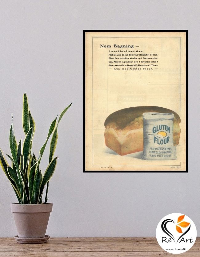 Billedet er en væg med en plante foran. På væggen hænger en plakat, som er original reklameplakat fra Munke Mølle for Gluten Flour. På billedet er et franskbrød og en pose mel foran fra Munke Mølle
